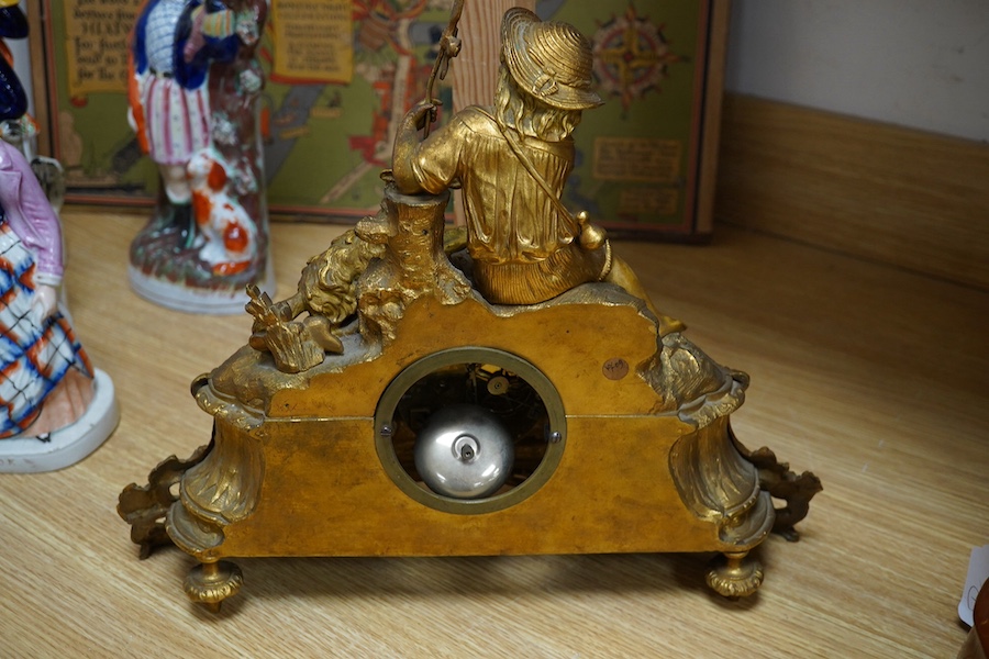 An early 20th century French ormolu clock surmounted with a boy and dog, striking on a bell, 41cm wide. Condition - fair, one hand missing, untested